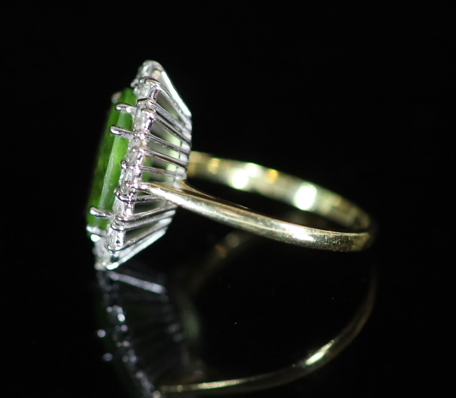 A modern 18ct gold, peridot and diamond set oval cluster ring